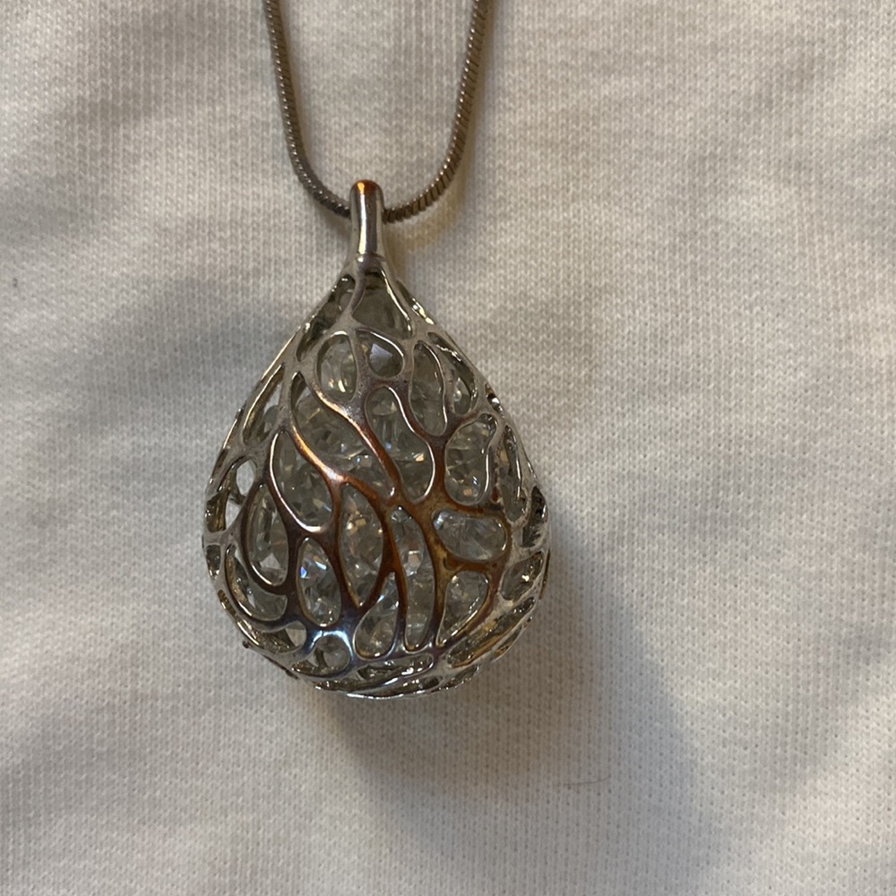 Silver necklace with caged pendant containing crystals